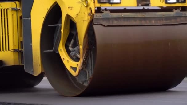 Pavimentadora, o una máquina para la colocación de asfalto nuevo caliente en una calle de la ciudad. — Vídeo de stock