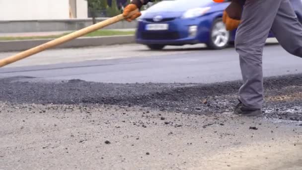 Ett team av arbetare lägger varm asfalt på spåren av en gata — Stockvideo