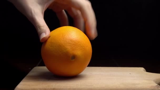 Proces van het reinigen van mandarijn. handen schoon mandarijn op zwarte achtergrond. — Stockvideo