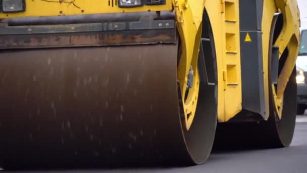 Pavimentadora, o una máquina para la colocación de asfalto nuevo caliente en una calle de la ciudad. — Vídeo de stock