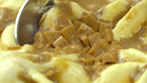 Makroschuss, ein Löffel wird in das Dessert abgesenkt, Vanilleeis bestreut — Stockvideo