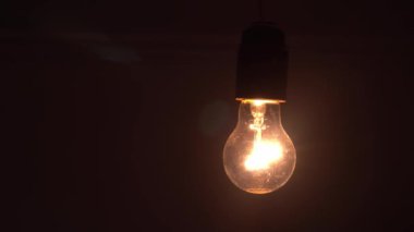 Tungsten ampul montajlı lamba siyah arkaplanda yavaşça açılıp kapanıyor