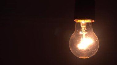 Tungsten ampul montajlı lamba siyah arkaplanda yavaşça açılıp kapanıyor