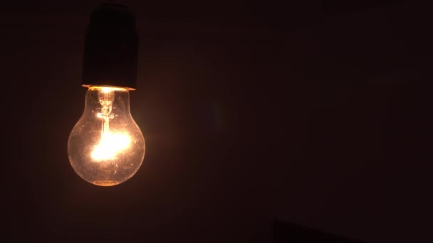 Lampa s wolframovou žárovkou se pomalu zapíná a vypíná na černém pozadí — Stock video