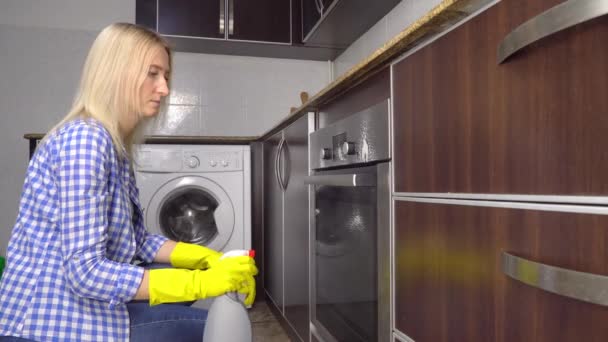 Жінка в жовтій гумовій захисній рукавичці очищає газову плиту з жовтою губкою . — стокове відео