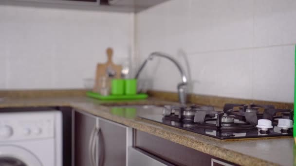 Rotate camera from kitchen focus to bottles of cleaning and detergent. — Stock Video