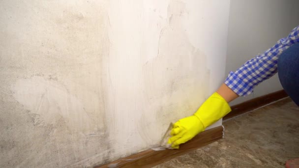 Blondine, wäscht weiße Wand in Wohnung mit Schaum, Schwämme in gelben Handschuhen — Stockvideo
