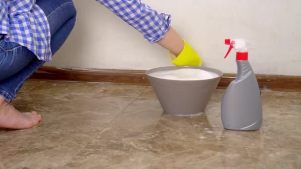 Blonde, washes white wall in apartment with foam, sponges in yellow gloves — Stock Video