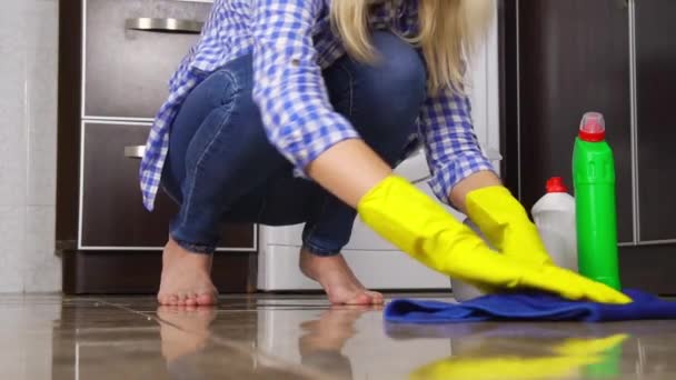 Młoda kobieta w myjniach z bliska kuca lub klęczy na podłodze. — Wideo stockowe