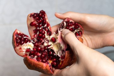 Açık sulu, sulu bir nar tutan kadın elleri yakın plan.