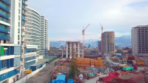 Drone view of construction of multi-storey buildings background of mountains. — Stock Video