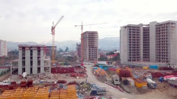 Drönare syn på byggandet av flervåningshus bakgrund berg. — Stockvideo