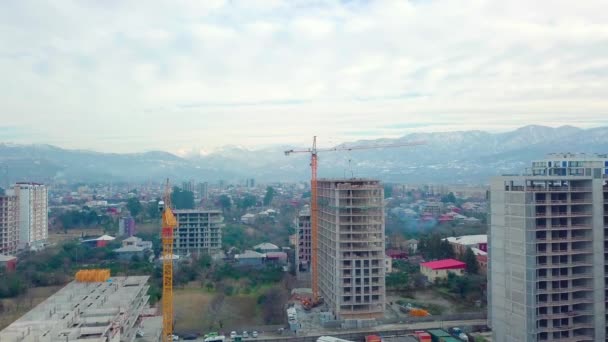 Drone view of construction of multi-storey buildings background of mountains. — Stock Video