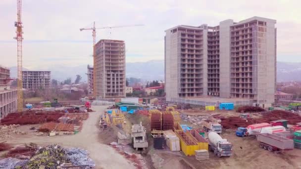 Vue par drone de la construction de bâtiments à plusieurs étages fond de montagnes. — Video