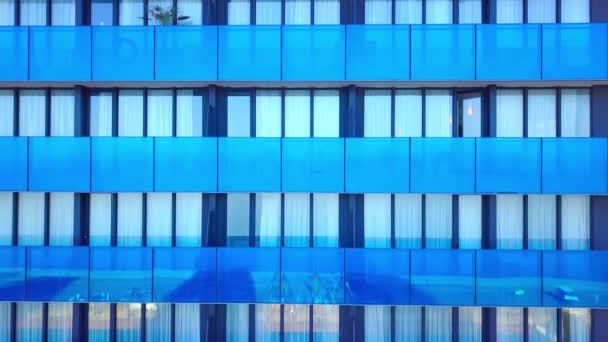 Shot of reflections of sun, clouds and sky on glass windows of city skyscraper. — Stock Video