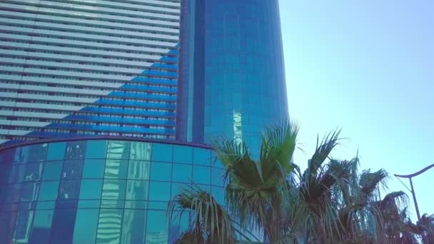 Shot of reflections of sun, clouds and sky on glass windows of city skyscraper. — Stock Video