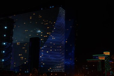 Gece vakti Batumi 'de parıldayan modern bir otel binasının yakın çekimi.