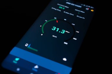 Siyah bir arkaplan üzerinde internet hız kontrolü olan bir cep telefonunun yakın plan görüntüsü