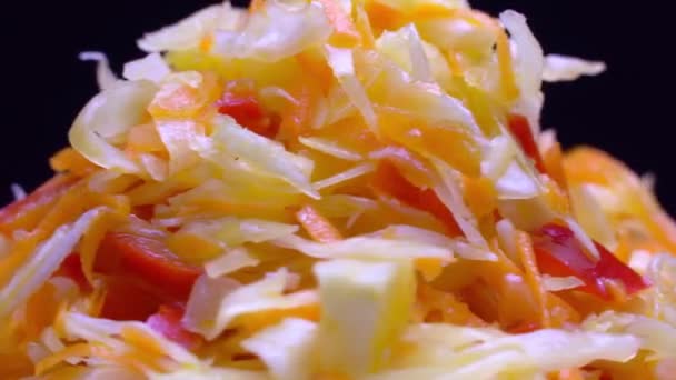 Salade van verse groenten op een witte plaat draait op zwarte achtergrond. — Stockvideo