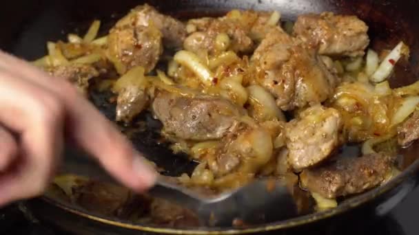 Ręka kobiety odwraca smażone mięso wieprzowe na patelni.. — Wideo stockowe