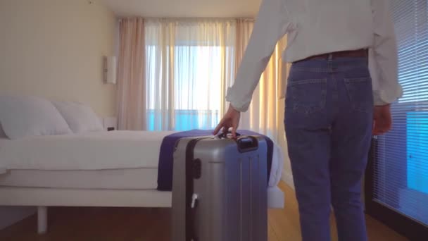 Egy fiatal nő belép a szobába egy bőrönddel, kinyitja a csipke függönyt, — Stock videók