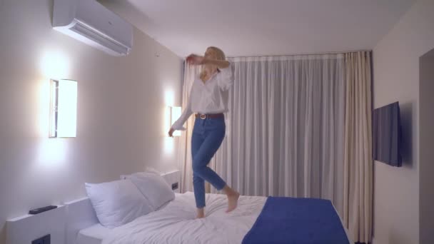 Una mujer está bailando en la cama con la música. — Vídeos de Stock