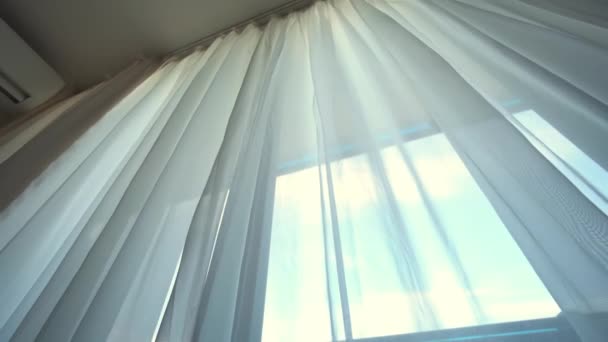 바람은 방의 열린 창문을 통해 불고 있습니다. 창문으로 커튼을 튀기는 모습 — 비디오