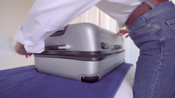 Une jeune belle femme en chemise blanche sort les choses d'une valise — Video