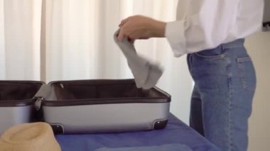 Noel Baba şapkalı güzel bir kadın bir bavulda bir şeyler topluyor.
