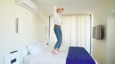 Bir kadın müzik eşliğinde yatakta dans ediyor..
