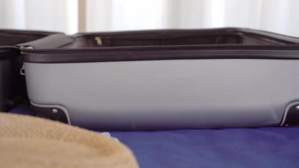 A young beautiful woman in a Santa Claus hat collects things in a suitcase — Stock Video