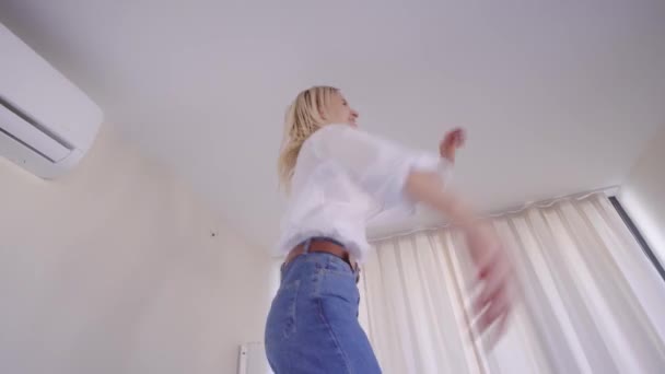 Una mujer está bailando en la cama con la música. — Vídeo de stock