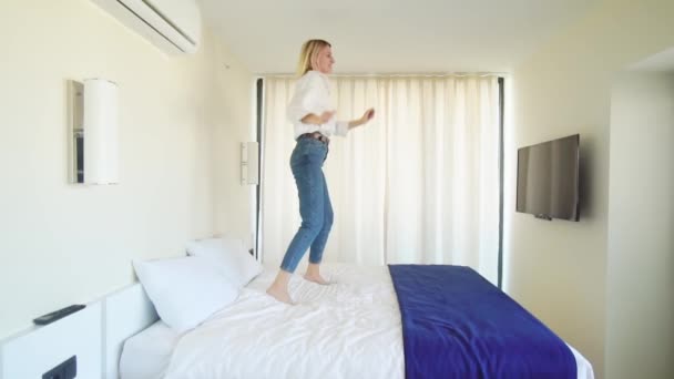 Una mujer está bailando en la cama con la música. — Vídeos de Stock