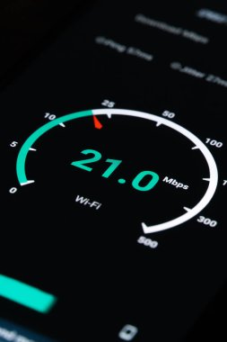 Siyah arkaplan dikey fotoğrafında bir cep telefonunun İnternet hızını kontrol etmenin sonucu olarak yakın plan