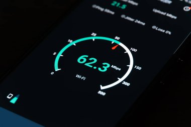 Siyah arkaplandaki bir cep telefonunda İnternet hızını kontrol etmenin sonucu olarak yakın plan