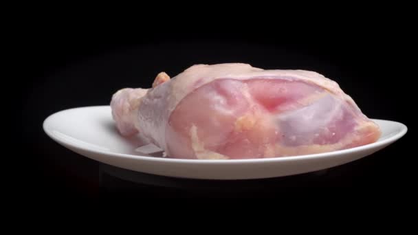 Куриная нога или бедро с голенью лежит на белой тарелке и вращается на поворотном столе — стоковое видео