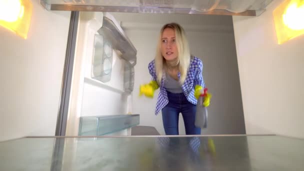 Egy nő belenéz a hűtőbe és sikoltozik. Stressz. takarítás. — Stock videók