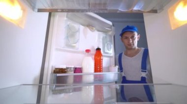 Buzdolabı tamircisi kapıyı açar ve sınıfa başparmak işareti yapar..