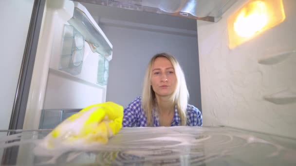 불만을 품고 화 가난 한 여자가 냉장고 안을 씻고 청소 한다 — 비디오