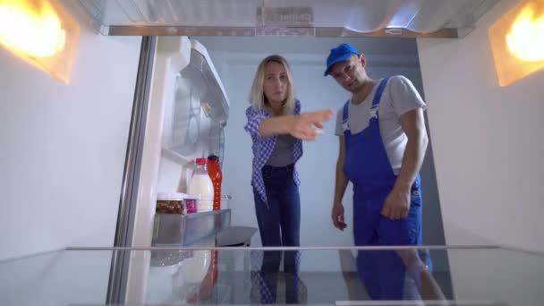 Kylskåpsreparatören och hyresvärdinnan kramas, antydan till sex. — Stockvideo