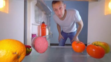 Adam boş olan buzdolabını açar ve göbeğini yağla gösterir..