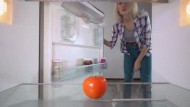 Kadın sadece domatesleri olan buzdolabını açıyor. Çok üzgün..