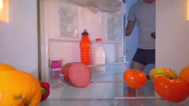 Hombre abre refrigerador y pone la tarjeta video sobrecalentada en el estante para enfriar. — Vídeos de Stock