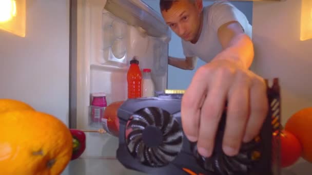Man opens refrigerator and puts overheated video card on shelf for cooling. — Stock Video