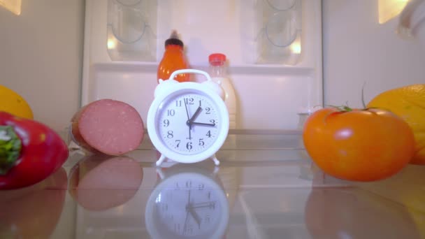 Um jovem ou homem abre a geladeira, que tem um despertador, ele leva — Vídeo de Stock