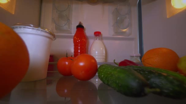 Dívka otevře ledničku a vyndá rajče. pohled zevnitř. — Stock video