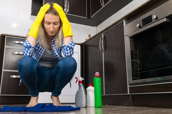 Sarı Lastik Eldivenli Üzgün Genç Kadın Mutfakta Çömeliyor Kafasını Tutuyor — Stok fotoğraf