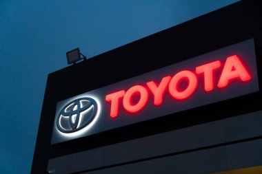 Batumi, Gürcistan - 26 Ocak 2022: Toyota bayiliğinin logosu akşam saatlerinde gökyüzüne karşı aydınlandı