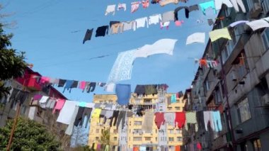 Çamaşırlar, çok katlı eski bir binanın avlusunda asılı duruyor..