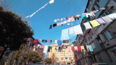 Çamaşırlar, çok katlı eski bir binanın avlusunda asılı duruyor..
